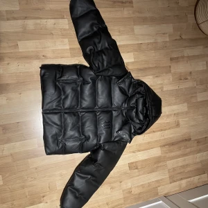 Wasted Paris ”Puffer Hood” Dunjacka - Säljer en dunjacka från Wasted Paris i storlek L.  Jackan är gjort i konstläder och har aldrig använt den då jag fick den nyligen. Säljer pga hittat en annan. Jackan har ett tryck på framsidan och baksidan. DM för frågor