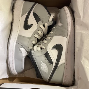 Air Jordan 1 Mid (GS) - Som nya jordans. Använd Max 5 gånger. Modellen (LT smoke grey/White-anthracite gris fume Claire/blanc) köpt för 2100 kr säljer för 1400 kr. Storlek 38 men jag som även använder 37 eller 39 i vissa fall tycker de är bekväma. 