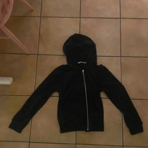 Svart hoodie - Svart hoodie, drag kedja kroken lite sönder men den funkar ändå. Priset kan diskuteras, De står M men den sitter lite taijtare så skulle säga ca m/s 