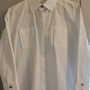 Busnel vit bomullsskjorta vit i lite längre modell endast provad.