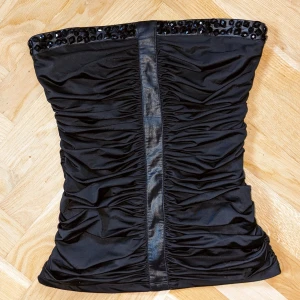 y2k tube topp - svart y2k strapless topp med svarta glasstenar som jag köpte i Berlin 💥 lite för stor för mig därav säljer jag💞 80 cm runt översta delen