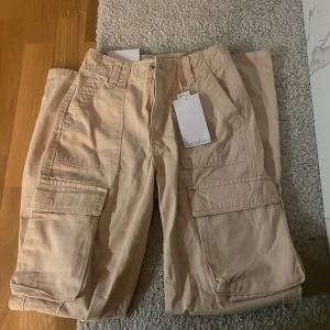 Nya Berschka cargopants - Nya cargopants med lapp kvar! Oanvända och jätte fina, tyckte inte färgen passade mig därför jag säljer dessa snygga byxor. Strl 32 