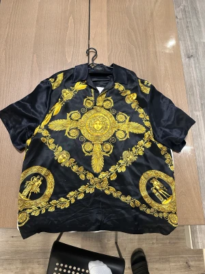 Maschera Baroque-print skjorta från Versace - Är i nyskick och denna skjortan är aldrig använd. Kvitto tillkommer. Nypris är 16000 men säljs för 3000 då jag vill använda pengarna till annat. Priset är diskutabelt vid snabb affär. Storlek är 52 vilket blir en XL men passar nån med 