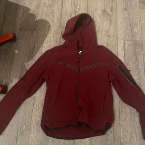 Nike tech set vinröd - Nike tech vinröd. Byxor: storlek S hoodie: Storlek M. Skick 9/10. Pris: 600 kan prutas.
