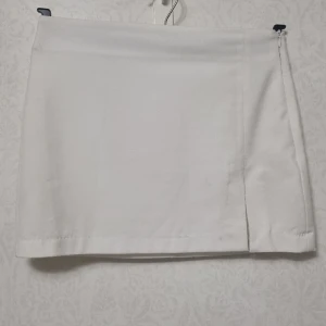 Vit minikjol - Vit minikjol från pull&bear. Dragkedja på sidan och ett slit på framsidan. 