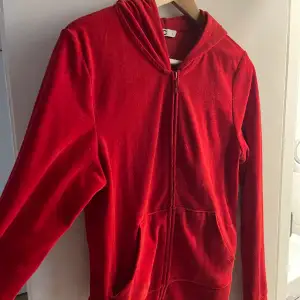 Röd zip-up hoodie med fickor.  Kund står för frakt (ca20kr). 