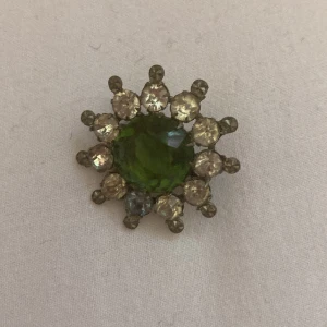 brosch med grön sten - Brosch med grön Sten och små stena runt (en av stenarna har en dock annan nyans)