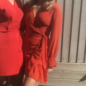 Volangklänning - En orange/röd volangklänninging från Gina i strl.38! En superfin sommarklänning, enbart använts en gång. Sälja pga att den ej kommer till användning. 