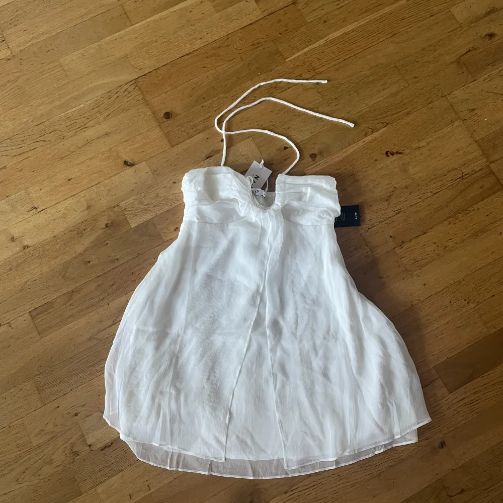 En superfin vit halterneck klänning. Storlek 38, aldrig använd (lapp kvar). Klänningar.