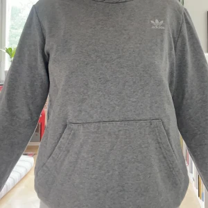 Adidas hoodie - Adidas hoodie till salu. Inga defekter förutom lite sliten vid handledsmudden men annars fint skick. Säljer då den tyvärr blivit för liten.. Kontakta för mer info!🥰