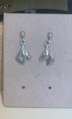 Hästörhängen i äkta silver  - Ett par fina små hästörhängen i äkta silver. Har använts ett par gånger. I äkta silver