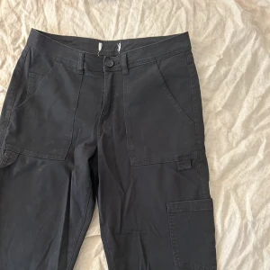 Raka cargobyxor - Gråsvarta, fickor baktill, raka ben. storlek S men passar mig som är en M.