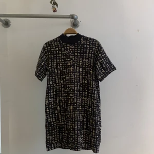 Mönstrad svart klänning m fickor  - Högt uppskattad klänning med semihög krage och fickor(!!). Funkar till alla tillfällen✨ Säljes pga har blivit för liten.. Trots att den har varit en av mina favoriter så har den inga skavanker utan behandlats älskavärt 