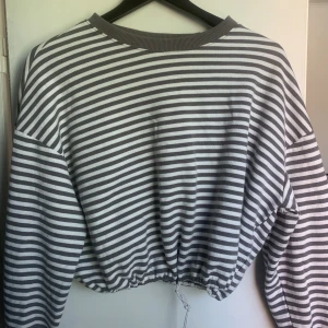 grå randig sweatshirt  - riktigt skön, går att spänna fast vid midjan!