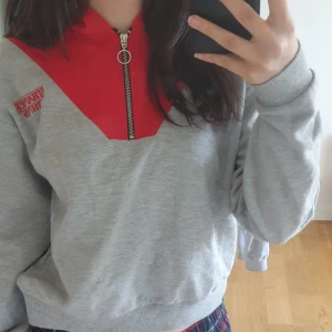 Hoodie Stranger things - Grå hoodie med röd luva. Stranger things. Stl 32/34  Använd en del men fint skick.