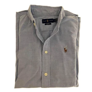 Oanvänd Ralph lauren skjorta strl 4 - Oanvänd Ralph lauren skjorta i ljusblå, storlek 4 perfekt till sommaren. 