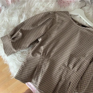 Elegant peplum blus - Säljer denna fina rutiga blus/topp som är aldrig använd då jag märkte efteråt att den var lite stor på mig