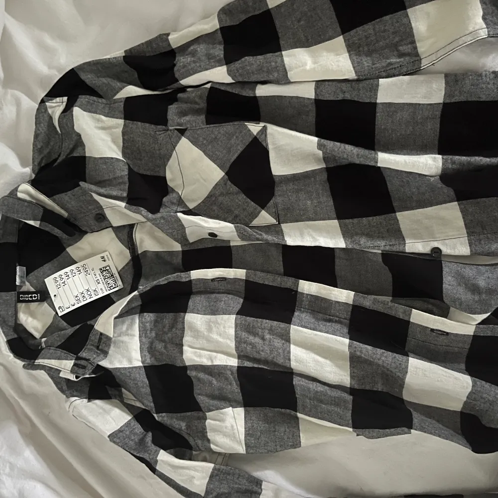 Rutig mönstrad skjorta svart/vit/grå i 100% bomull. Aldrig använd, lappen sitter kvar. Storlek XS. . Skjortor.