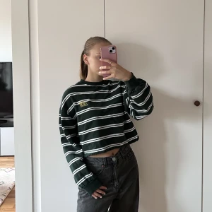 mörkgrön randig sweatshirt - Jättefin mörkgrön randig kort sweatshirt i XS från Junkyard. Det är ett gult litet tryck på den.  Använd men i bra skick! Hör av dig om du undrar något☺️👋🏼✨🤍