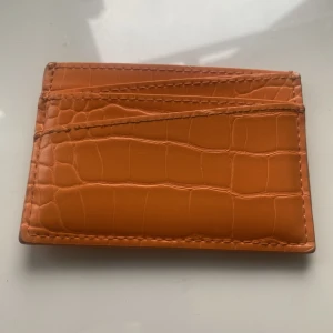 Korthållare  - Orange korthållare från MONKI.  Fraktkostnad tillkommer.