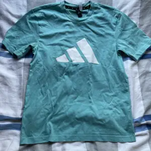 Säljer nu denna turkosa adidas T-shirt då den inte kommer till användning! Använd Max 5 ggr. Nypris är 399kr. Håller på och rensa garderoben så var inte rädda för att kolla resten av profilen!