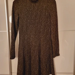Glittrig klänning - Festklänning svart med guldtråd, nyskick.