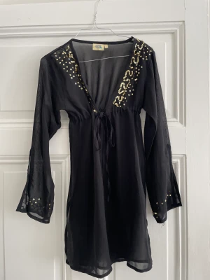 Strandtunika - Fin (genomskinlig) strandtunika med guldsetaljer (saknar några på armen som man inte riktigt tänker på) 