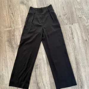 Kostymbyxor - Högmidjade kostymbyxor från HM. De är lite vida och raka i modellen. Perfekt längd för runt 160cm. 