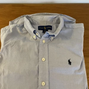 Ralph Lauren - Fin ljusblå skjorta.  Äkta Ralph Lauren.  14-år i storlek.  Men lite små i storlekarna, så 12-13 är nog lagom. 