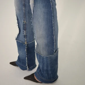 REMAKE FORNARINA JEANS - Storlek: Midja (78 cm), Innerbenslängd (95 cm), Total Längd (112 cm) Blå, remake, långmidjade bootcut jeans med sömmar på utsidan. Jeansen är långa och man kan själv klippa byxorna utifrå