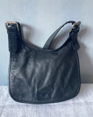 Messenger bag/väska i skinn - Messenger väska från WERA i fint använt skick! Reglerbar axelrem och tre små fack i varav en av dom med dragkedja, sen en med dragkedja utanpå under ”flärpen” som syns på bild. Lite y2k, 00-tal, 90-tal stil på väskan.   24cm i höjd och 27cm i bredd!