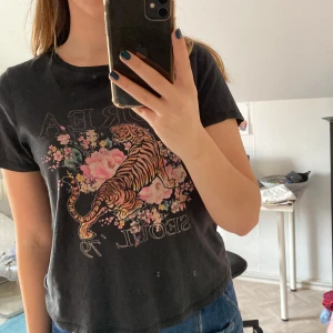 T-shirt - En välanvänd t-shirt som inte är min stil längre. Den har två små hål som knappt syns men annars är den i okej skick.