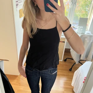 Linne - Svart fint linne från Samsøe Samsøe. Linnet sitter högre upp på framsidan och har en låg rygg. Har dubbelt tyg - så ej genomskinlig