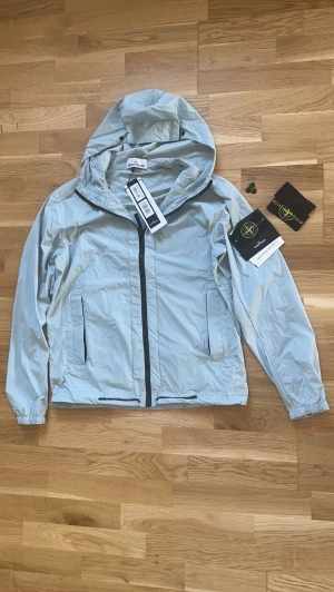 Stone island regn jacka i färgen Sky Blue Storlek (M) - Köpt några 2 månader sen men aldrig använt typ för jag vill hellre sälja den elle vänta tills den passar mig för sen är lite för stor för mig 