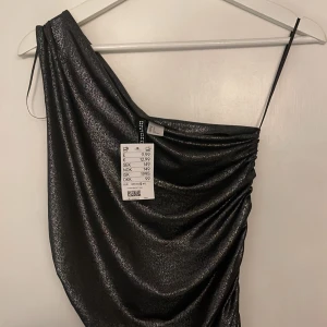 Glittertopp - Super snygg helt ny topp ifrån Hm, säljes då den tyvärr är för liten. Har jag för mig rätt är den helt slutsåld!🖤obs bilden med toppen på är lånad pågrund av att den är för liten!🖤