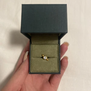 Maria Nilsdotter örhänge  - Örhänget är helt oanvänt då jag bara har ett hål i vardera öra, och att det även inte är min stil. Diamanten är månsten och det här örhänget är slutsålt.