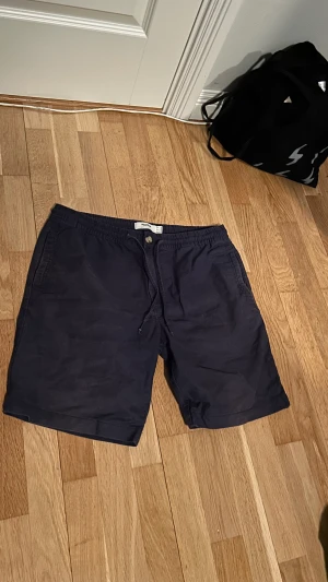 Mörkblå shorts - Snygga, i bra skick, känns och ser ut som linne material men tror att det är bomull.