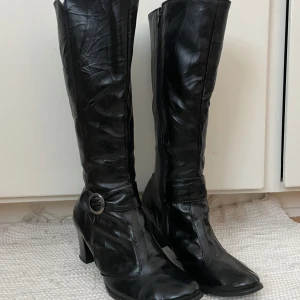 Svarta stövlar - Snygga svarta stövlar med klack. Perfekt till vintern, till kjolar och klänningar. Storlek 37 och höjden på skon är 41 cm och klacken är 7 cm.