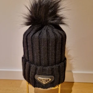 Prada Mössa *HELT NY!* - Säljer en helt ny, felfri svart Prada mössa. Den består av 30% ull vilket gör den mycket varm och passande för vintern!  