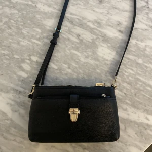 Väska Michael kors  - Mindre skinnväska från Michael kors i fint skick. Ytterfacket är till för korten och i det stora facket så får man plats med telefon m.m. Köpt på NK i Göteborg 