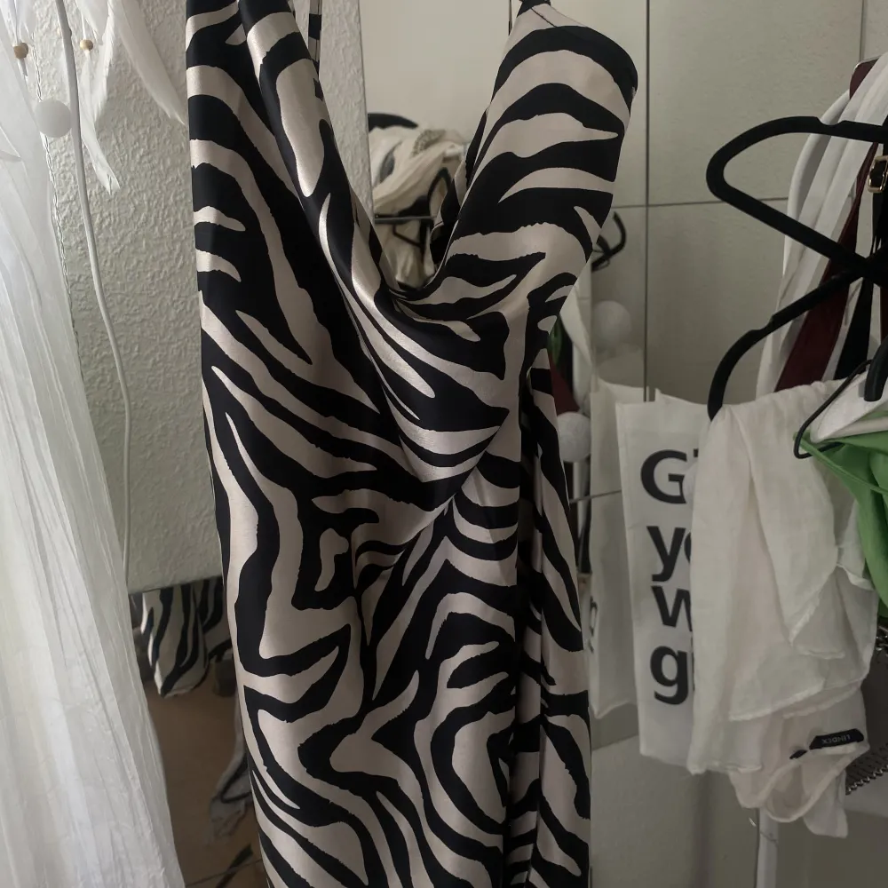 En jättefin satin klänning med zebra liknade mönster. Har använt en gång då den aldrig kommer till användning, så den är så gott som ny! Den är även korsad i ryggen, så om man vill ha fler bilder så går det bra 💕 Den hänger ner lite vid bysten också 💗. Klänningar.