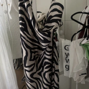 Zebra mönstrad klänning  - En jättefin satin klänning med zebra liknade mönster. Har använt en gång då den aldrig kommer till användning, så den är så gott som ny! Den är även korsad i ryggen, så om man vill ha fler bilder så går det bra 💕 Den hänger ner lite vid bysten också 💗