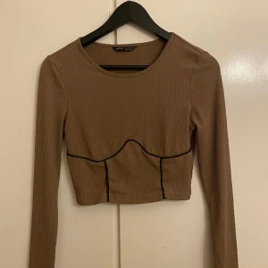 Tröja/Topp - Fin brun topp med svart streck på. Använd två gånger. Funkar för både S och M. Mer info är de bara att skriva.