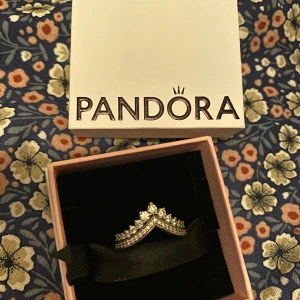 Pandora Prinsessa Wishbone Ring - Ny pris kostar 799kr Beställde online och ”provat en gång” Säljer pga. ”köpt fel i storlek” (storlek52) Helt ny! Säljer fast pris 480kr (med frakt +60kr)