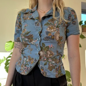 Blommig blus - Super söt blommig blus/topp, säljer eftersom den är lite för liten för mig. Den är i fint skick! Kolla gärna på min sida och se om ni vill ha något mer samtidigt, då blir frakten billigare!