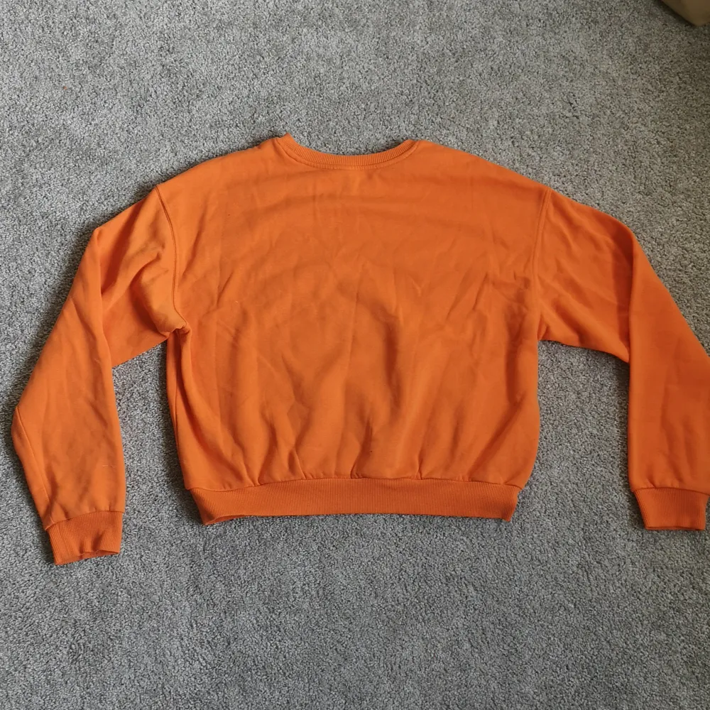 En supersnygg och skön collegetröja i orange färg. Har tryck på framsidan och i storlek M från divided. . Tröjor & Koftor.