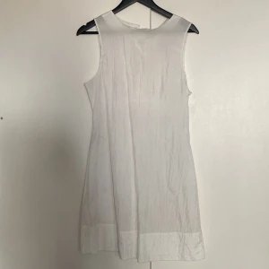 Vit klänning - Tunn vit klänning men en knapp har ramlat av, fungerar utmärkt med säkerhetsnål