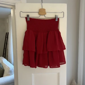 Röd Volangkjol  - Trendig och söt Volangkjol. Den är lite ljusare röd i verkligheten. Storlek 146/145 men skulle säga att den motsvarar en xxs. Endast använd 1 gång. 