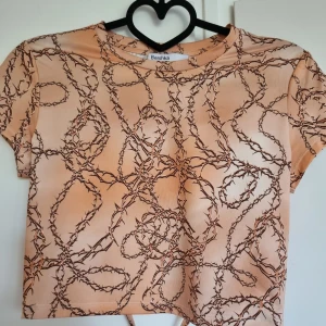 T-shirt från Bershka - Glansig orange/rosa topp från Bershka med knytdetalj i ryggen. 