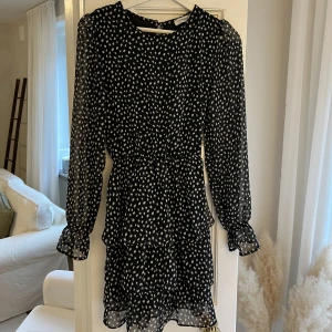 Prickig volangklänning - Prickig volangklänning från Chiquelle. Svart klänning med vita prickar. Använd 1 gång. 